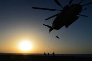  U.S. Marines with Battalion Landing Team 1st Battalion, 6th Marine Regiment, 22nd Marine Expeditionary Unit (MEU), rappel out of a CH-53E Super Stallion helicopter during a fast rope and rappel training exercise aboard the USS Bataan. (Sgt. Alisa J. Helin)